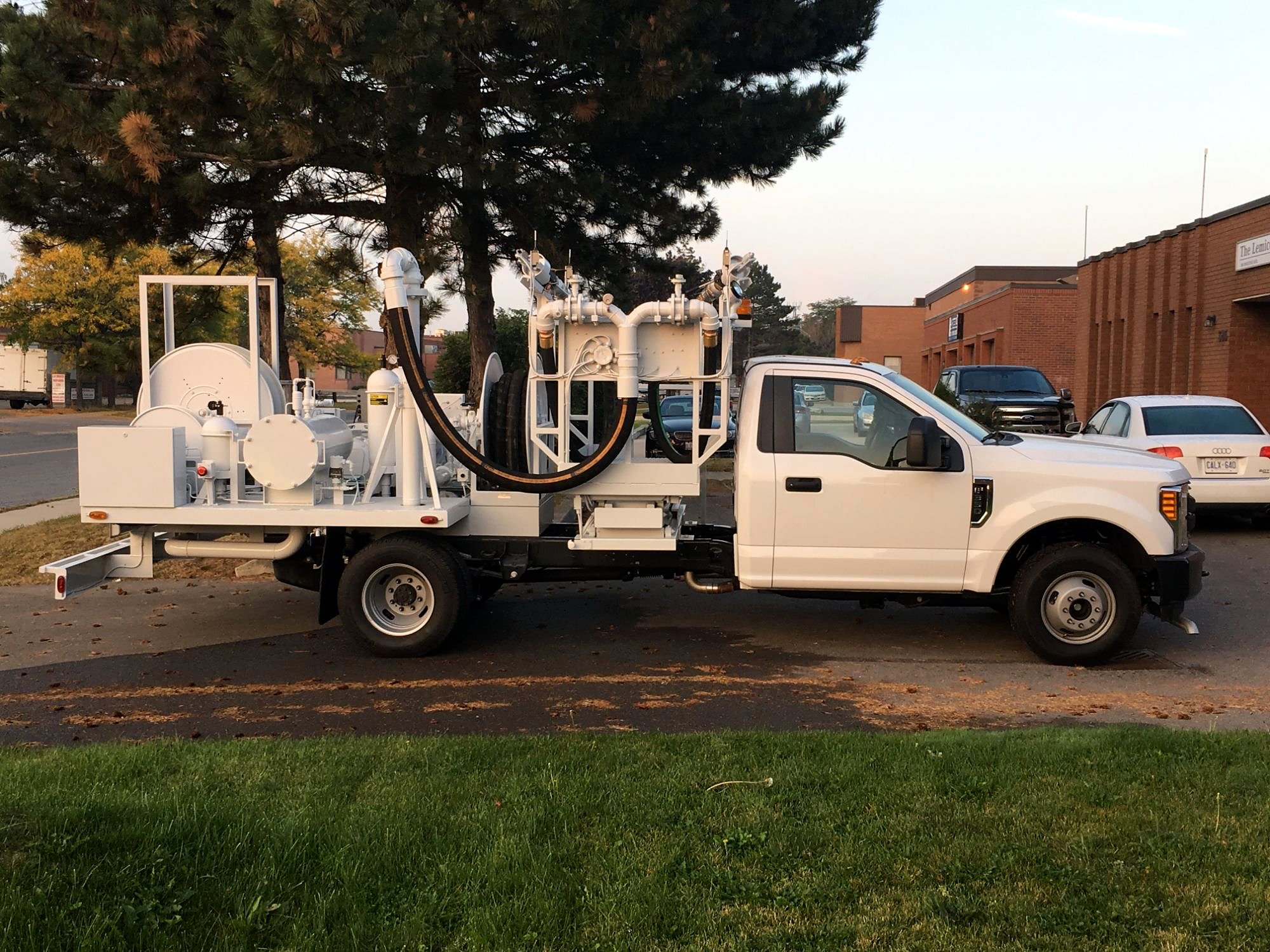 Hydrant servicer on a pickup chassis with lift platform, filtration and hose reels