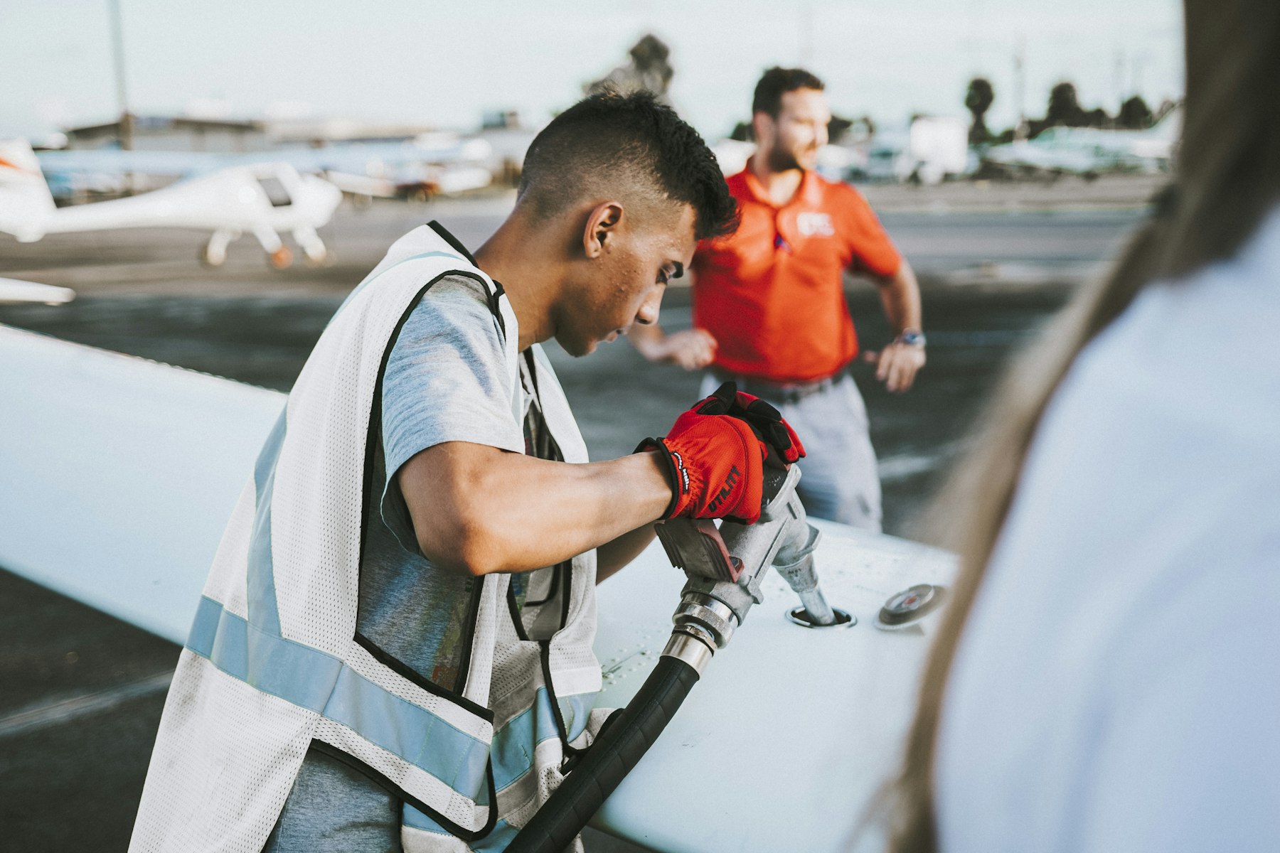 Ground crew fueling a light aircraft over the wing